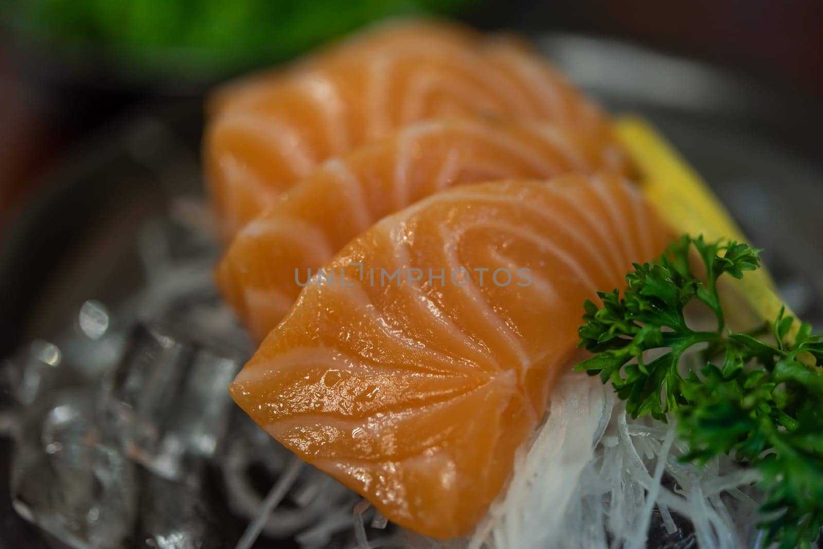 Japanese food delicacy consisting sashimi salmon of very fresh raw salmon fish sliced into thin pieces serving with radish sliced in japan restaurant