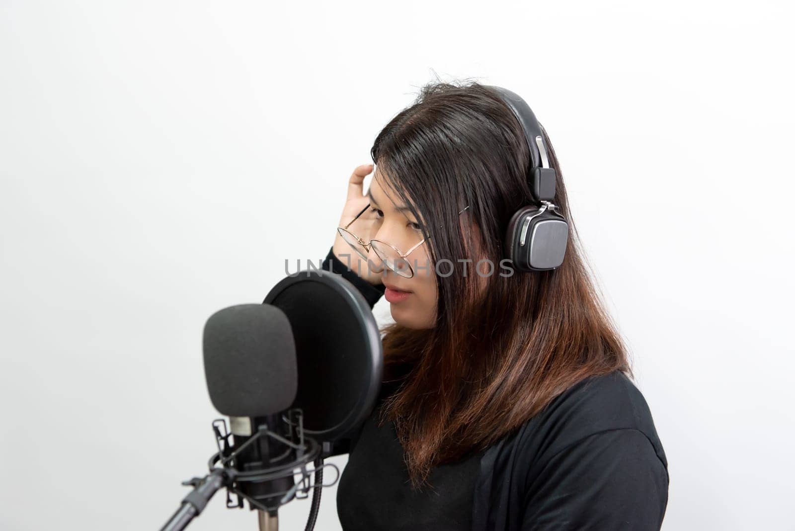 Beautiful asian woman (LGBTQ) is a singer. She enjoying sing a song or karaoke in music studio with microphone condenser and headphones for fun or voice creative