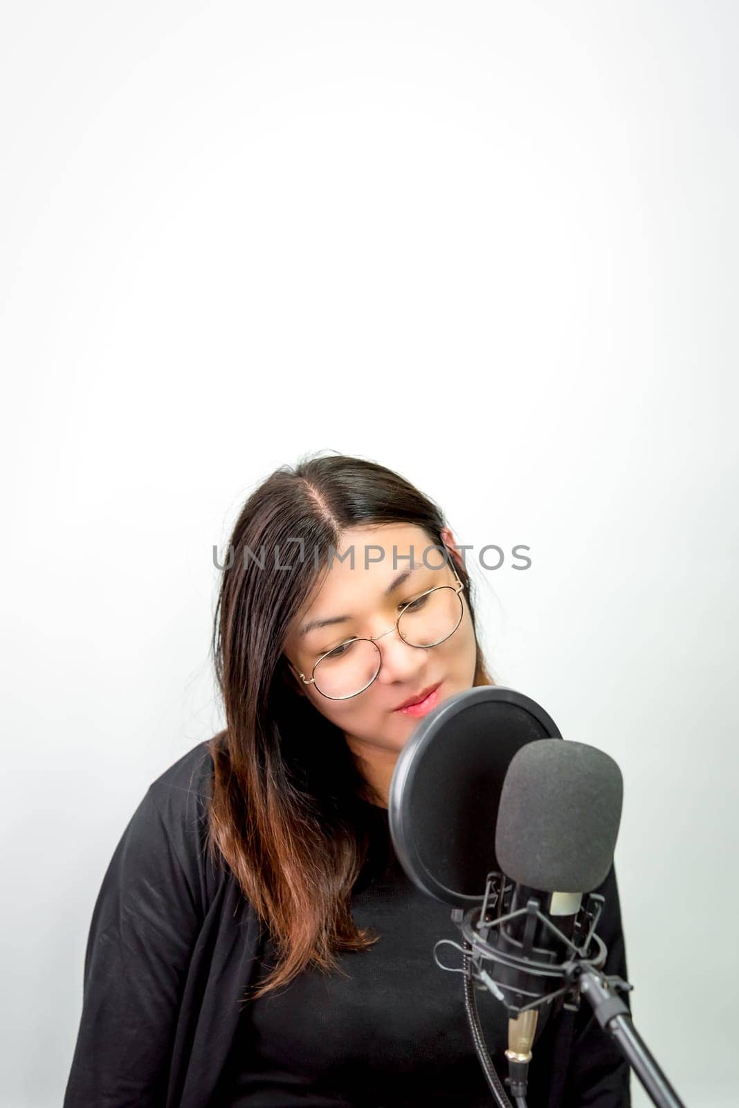 Beautiful asian woman (LGBTQ) is a singer. She enjoying sing a song or karaoke in music studio with microphone condenser and headphones for fun or voice creative