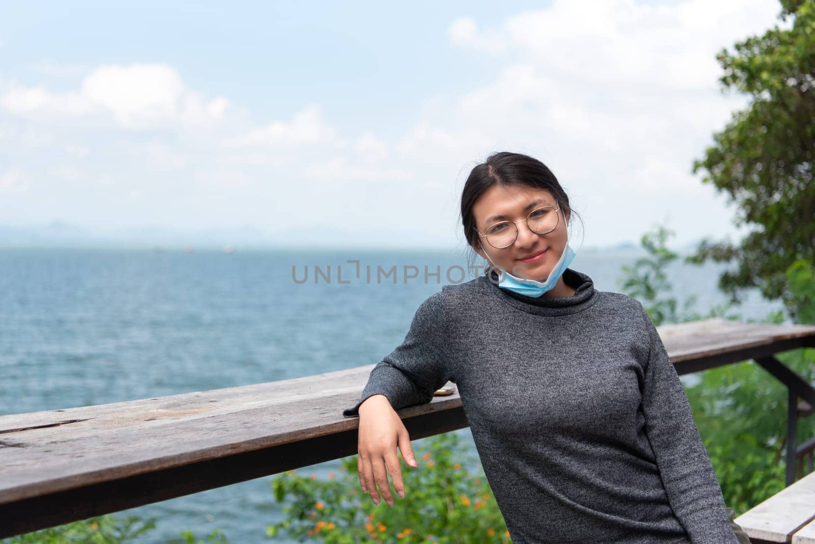 Beautiful asian woman (LGBTQ) natural makeup wear fashion relax clothes posing at sea viewpoint with happy and fun emotion in concept travel, vacation, leisure in life