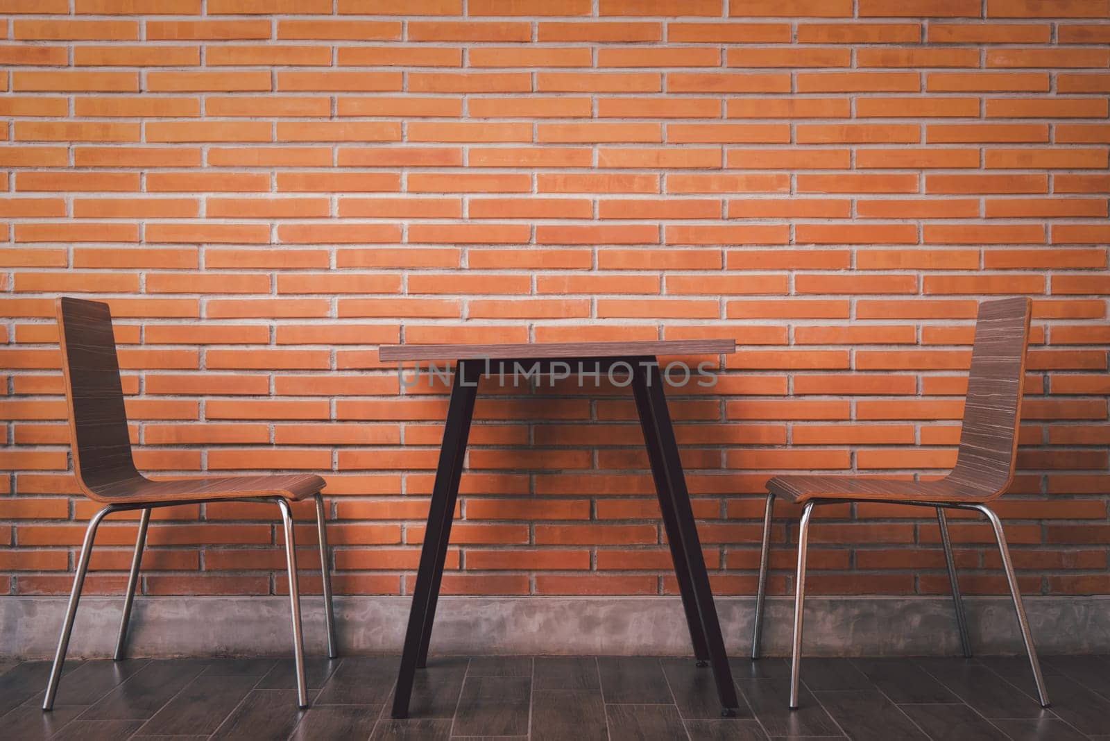 Balcony with red brick wall and table chairs set by PongMoji