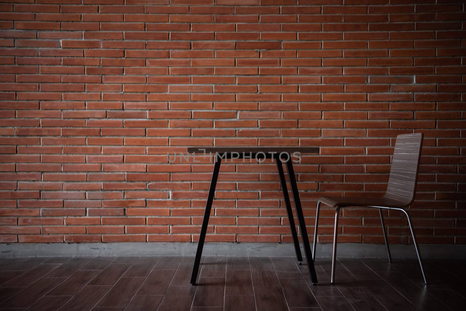 Balcony with red brick wall and table chairs set by PongMoji