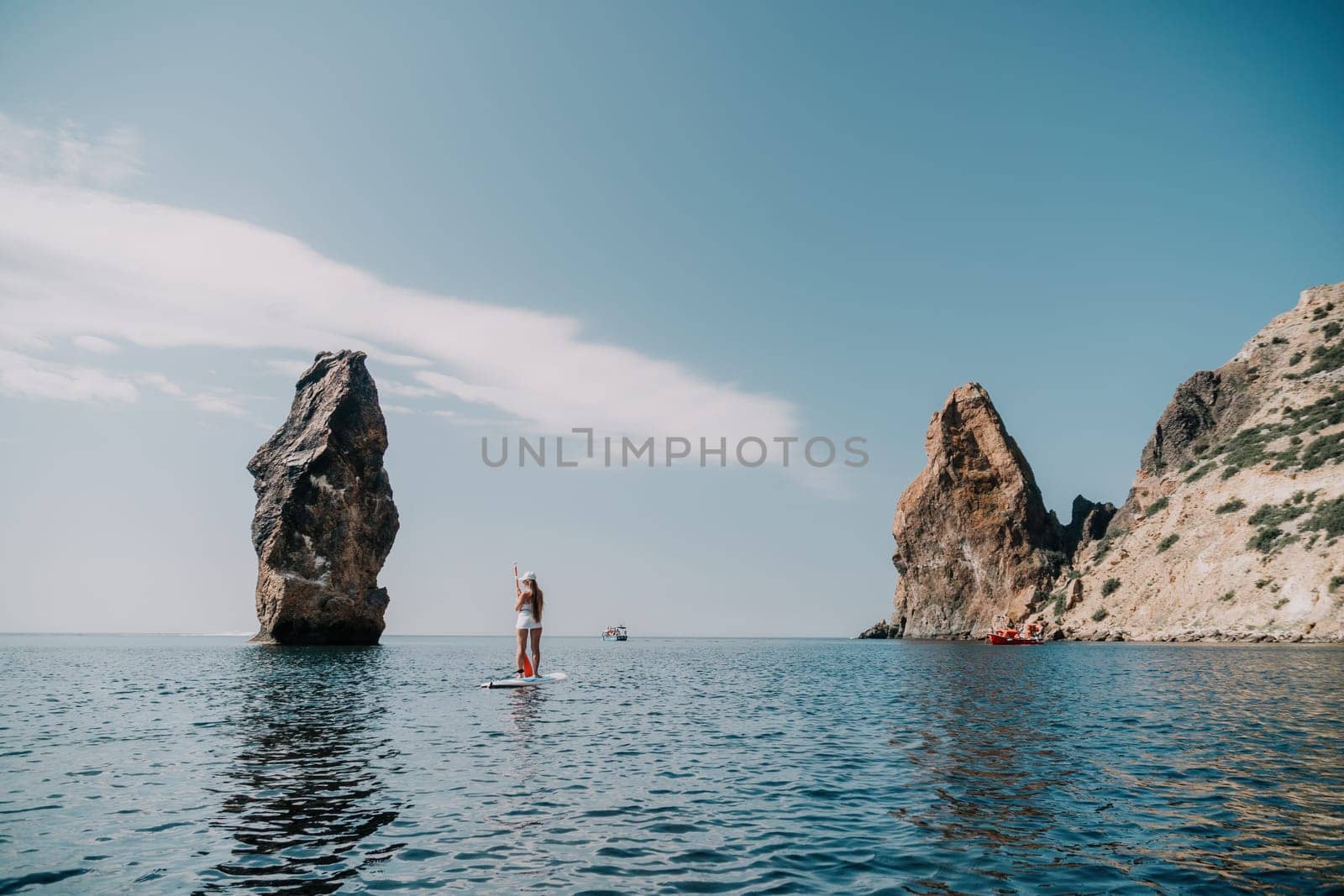 Woman sea sup. Close up portrait of happy young caucasian woman with long hair looking at camera and smiling. Cute woman portrait in bikini posing on sup board in the sea by panophotograph