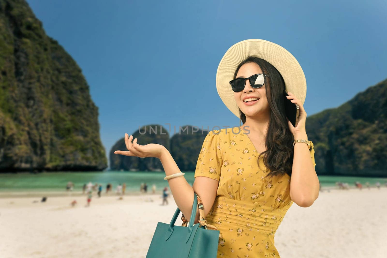 Beautiful woman in summer clothes talking on mobile phone, standing against sea background. Vacation, lifestyle, journey concept.