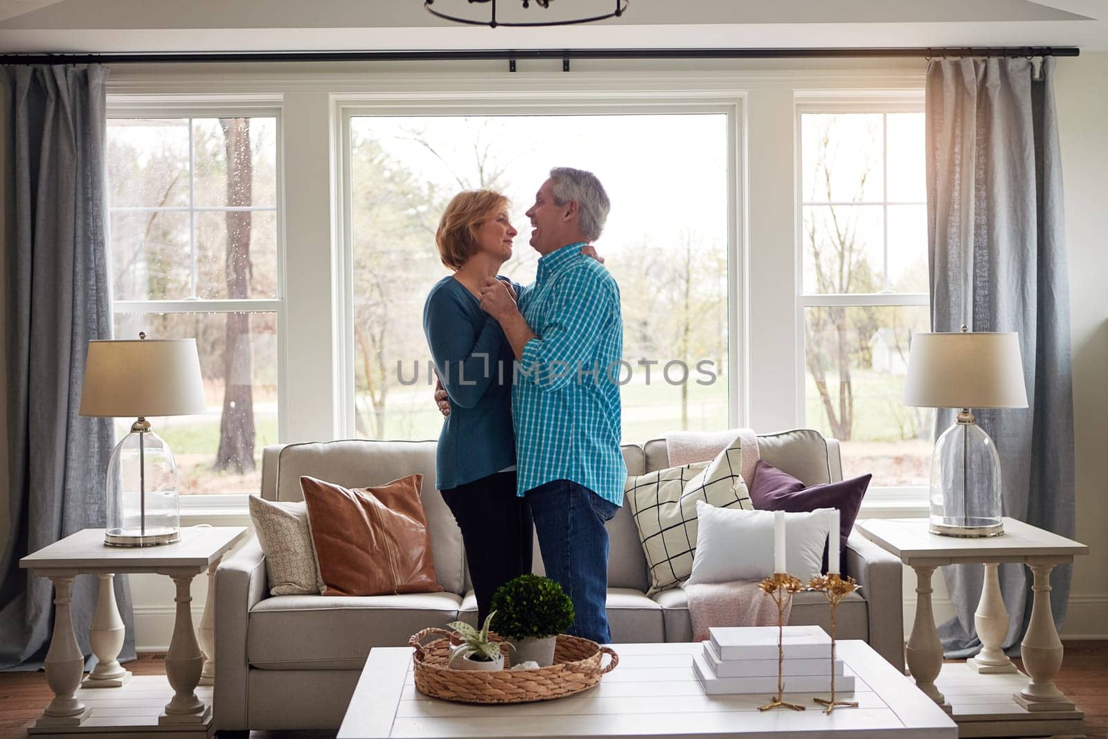 Good old fashioned romance is timeless. a happy mature couple dancing together in their living room at home
