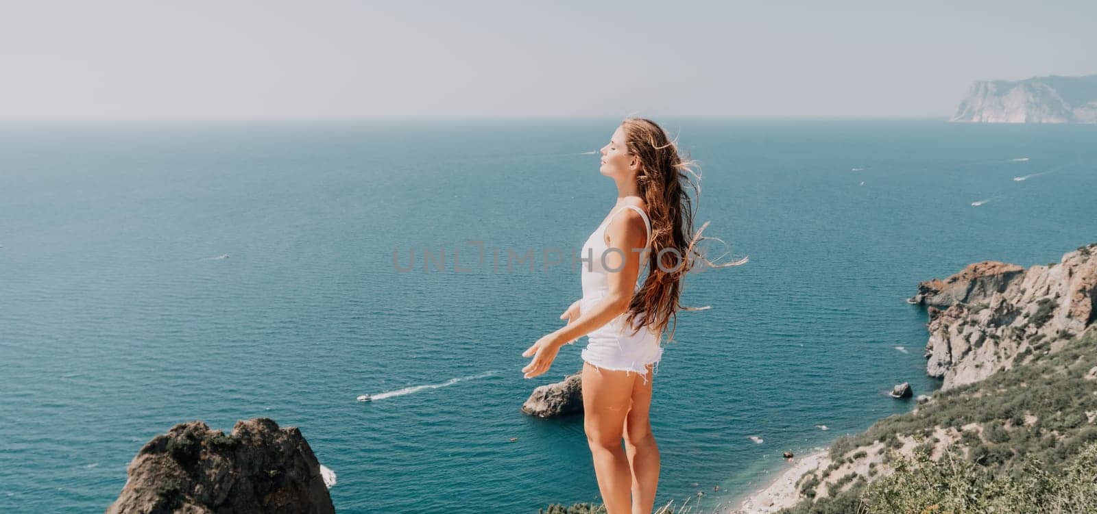 Woman summer travel sea. Happy tourist enjoy taking picture outdoors for memories. Woman traveler posing over sea bay surrounded by volcanic mountains, sharing travel adventure journey by panophotograph