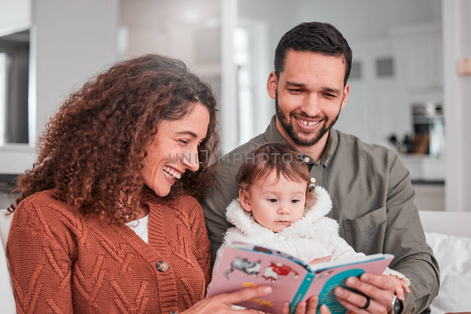 Parents, baby and reading story on sofa with smile, happiness and bonding with love in living room. Man, woman and child with book for learning, care and relax together on lounge couch in family home by YuriArcurs