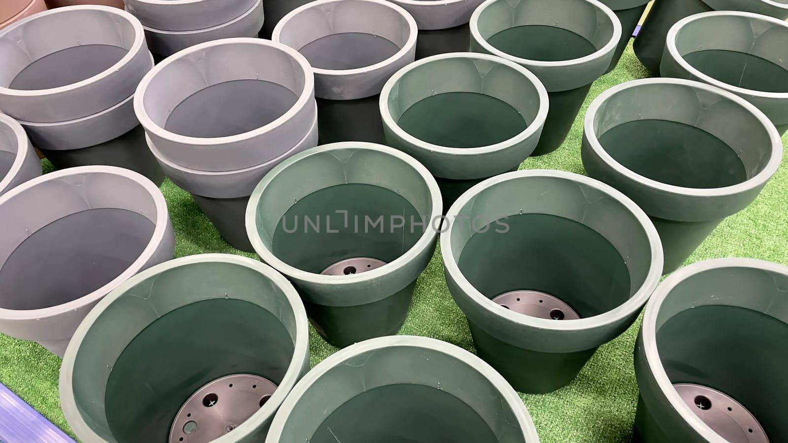 Close-up of empty flower pots in a store or greenhouse. Colorful pots for plants. Gardening and landscape design concept by Matiunina