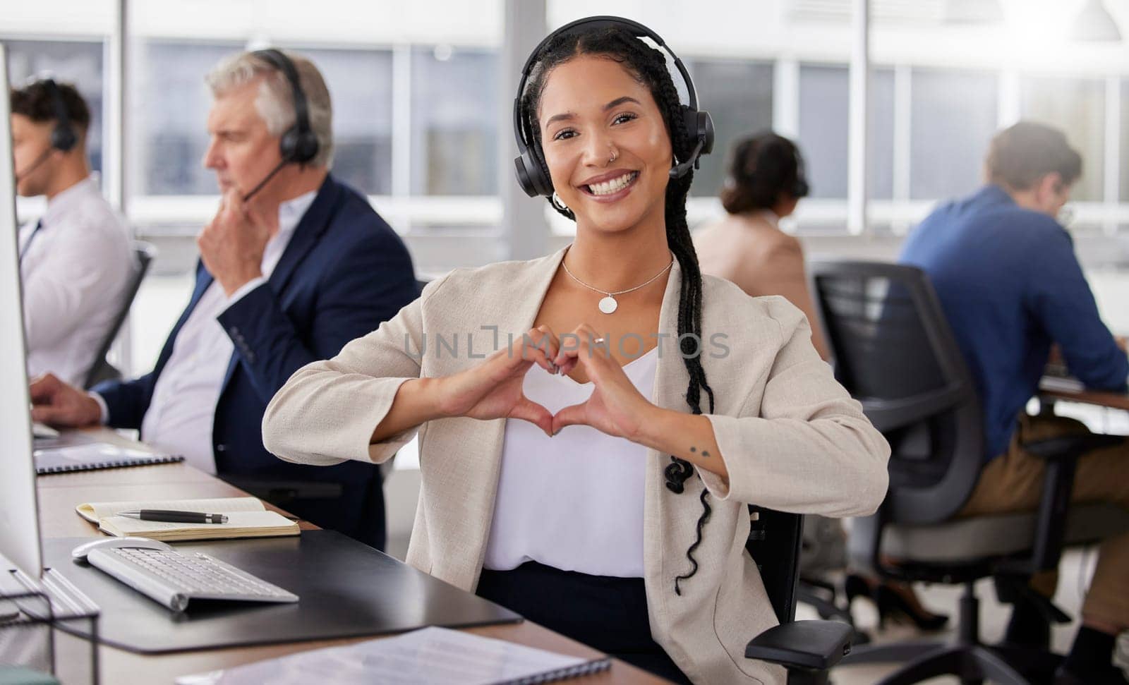 Hands, heart and portrait of happy woman in call center for customer care, excellence and sales support in office. Female consultant, gesture and love sign for telemarketing services, emoji and smile.