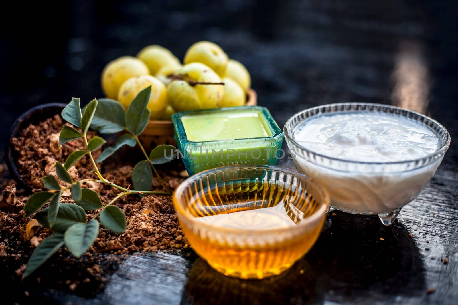 Close-up of herbal face pack of Indian gooseberry or amla with curd or yogurt and honey in a glass bowl on the wooden surface used to have instant bright skin.