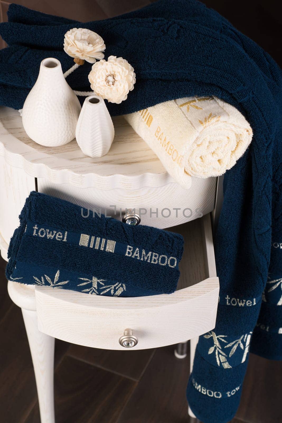 A vertical shot of a bathroom cabine with a drawer with navy blue bamboo towels by A_Karim