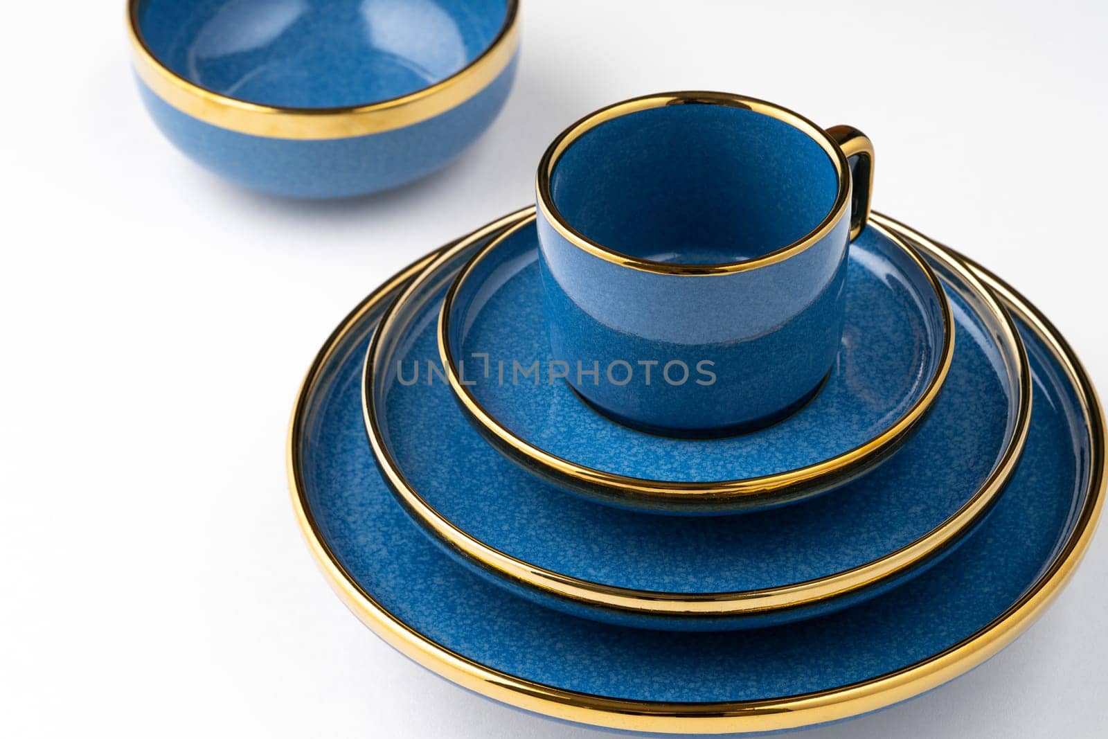 A set of blue ceramic plates and cup on a white background