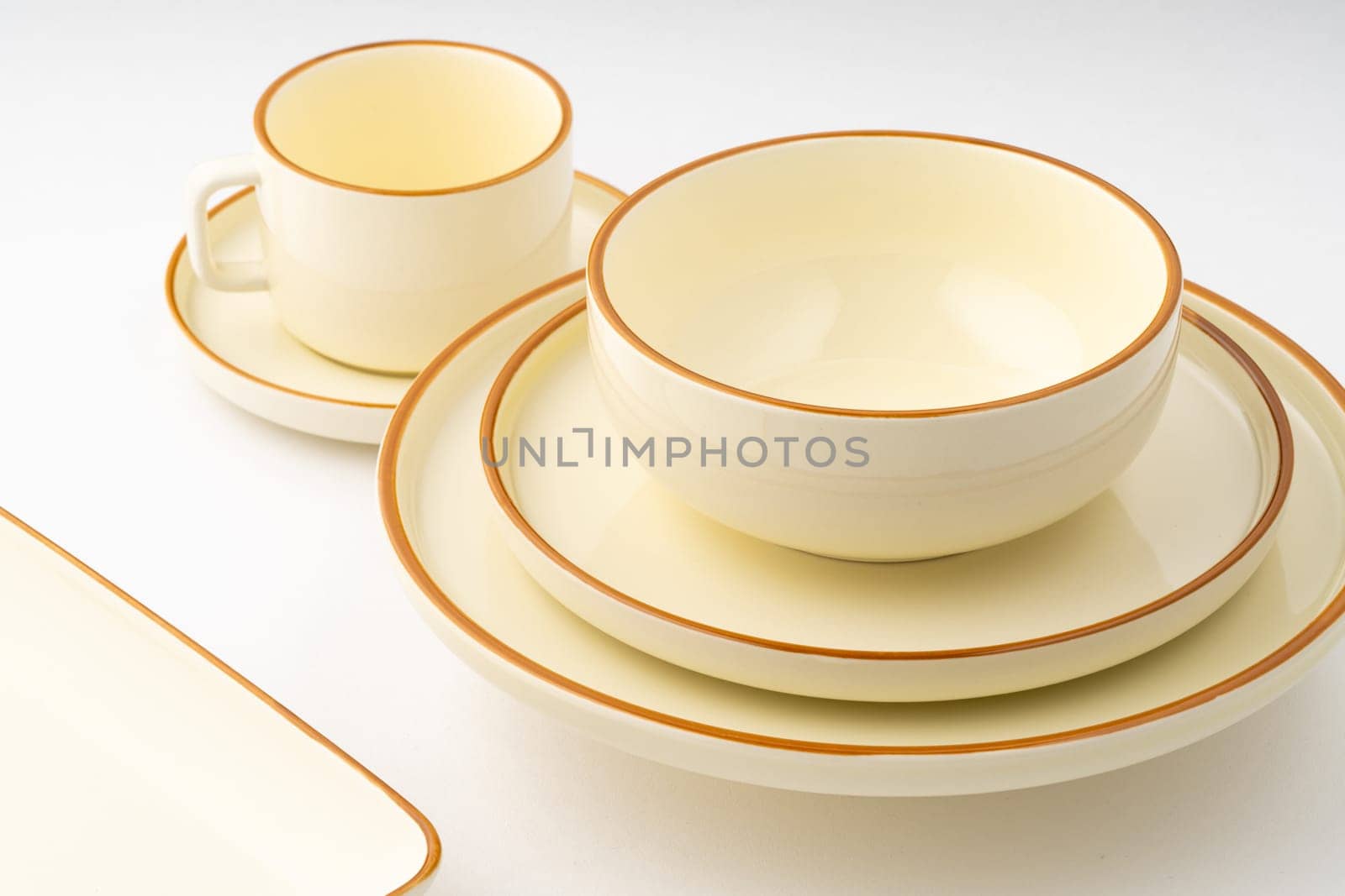 A set of white and brown ceramic plate and cup on a white background