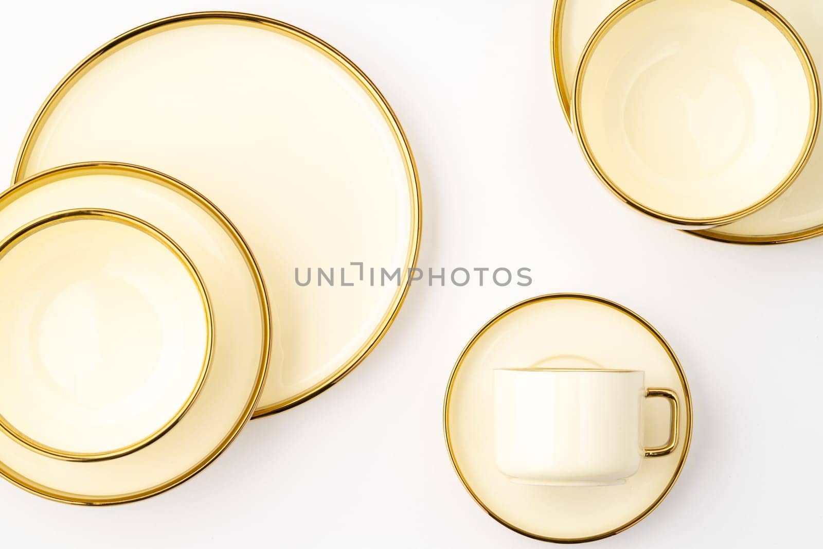 A set of golden luxury ceramic kitchen utensils on a white background