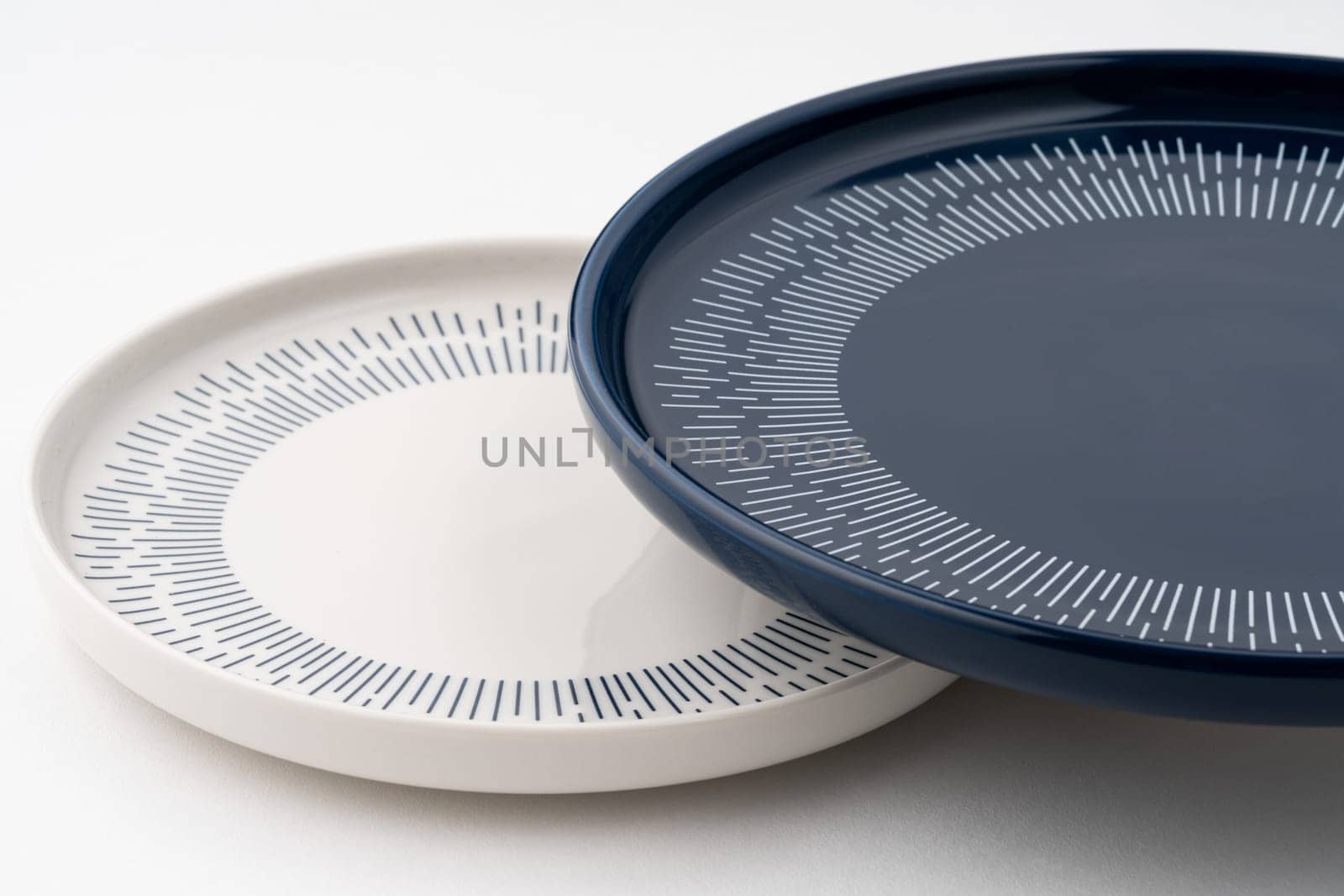 A closeup shot of a blue and white mug on a saucer with a white background