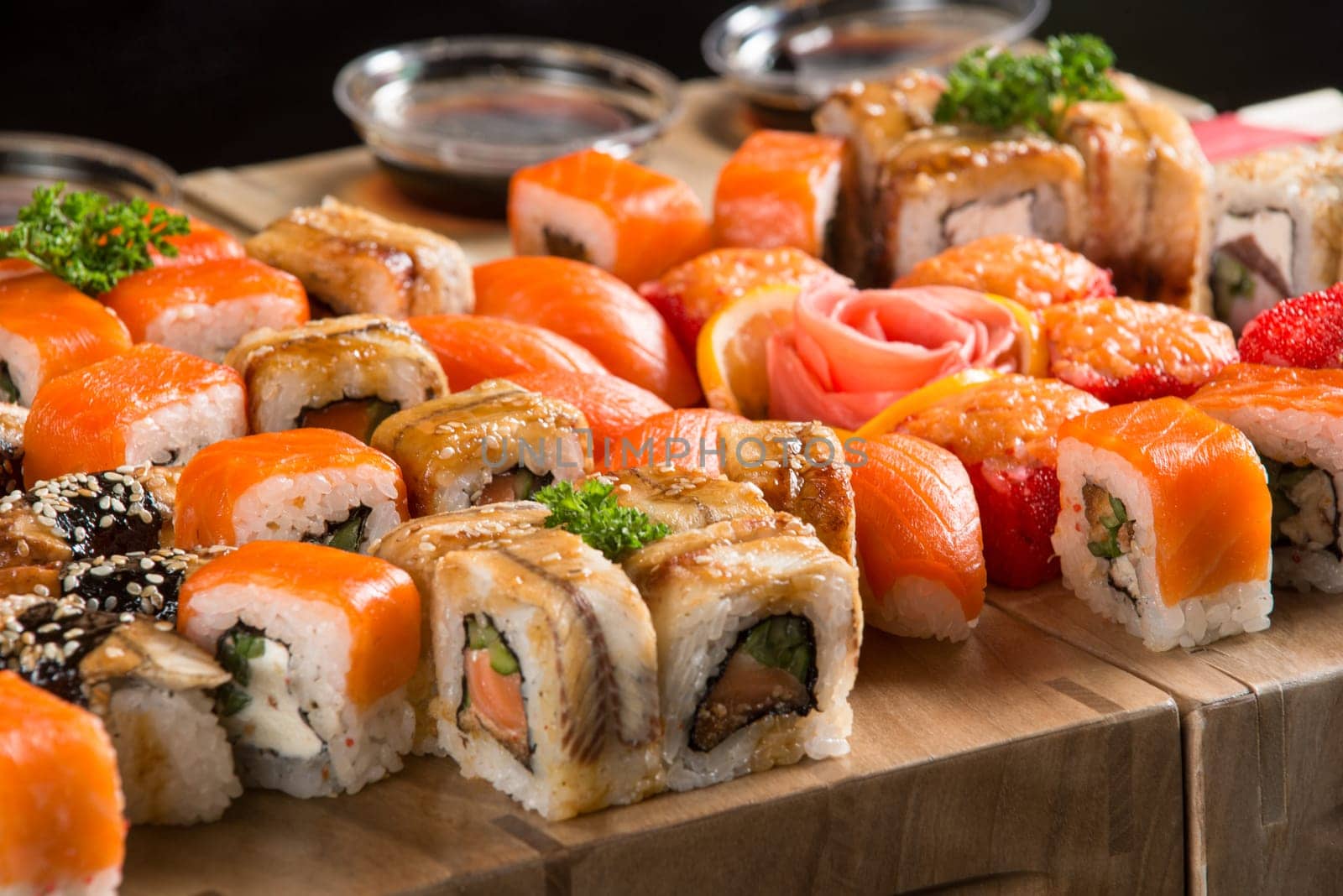 A closeup shot of a sushi set on a wooden plate