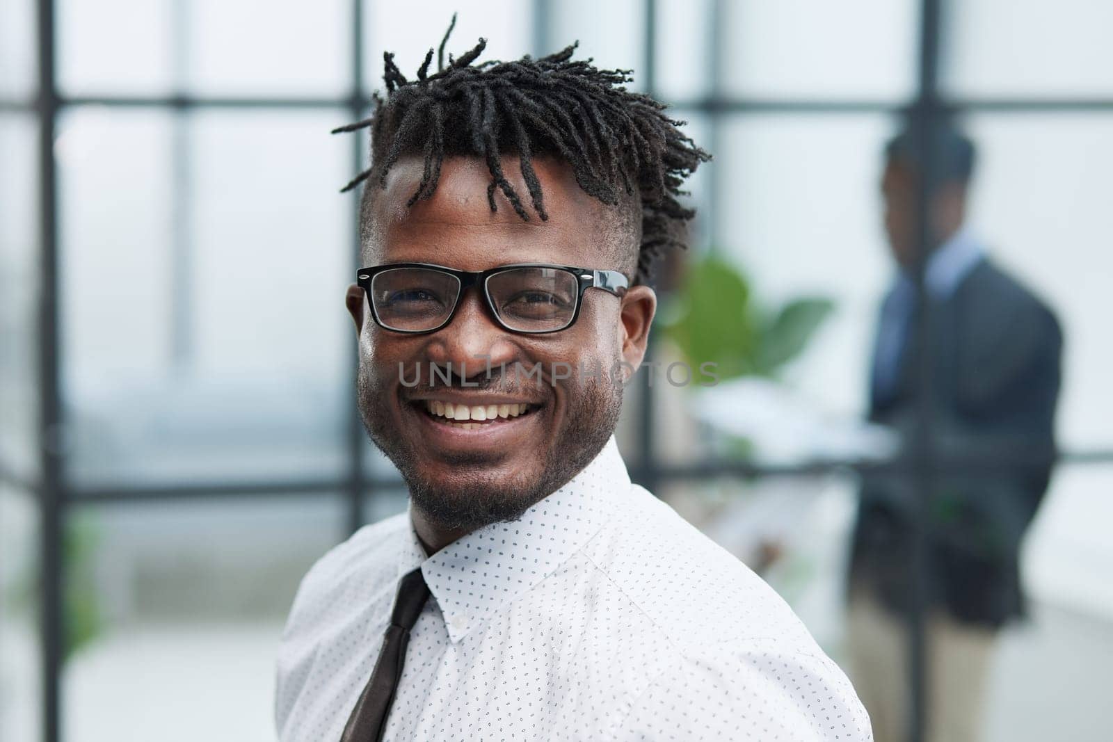 Close-up portrait of smiling handsome african american businessman in white shirt