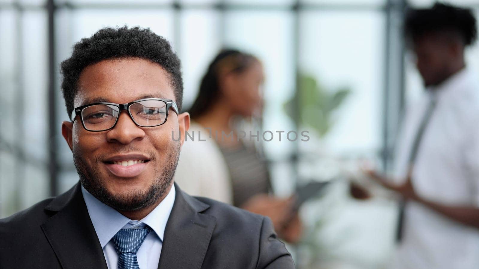 Attractive guy with a charming smile and glasses with arms folded in front