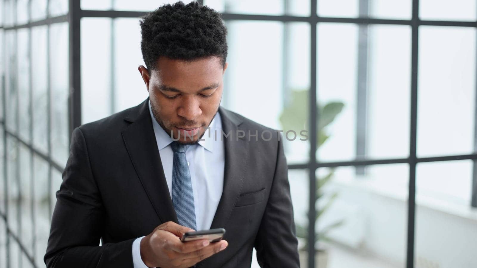 attractive african american young man uses phone