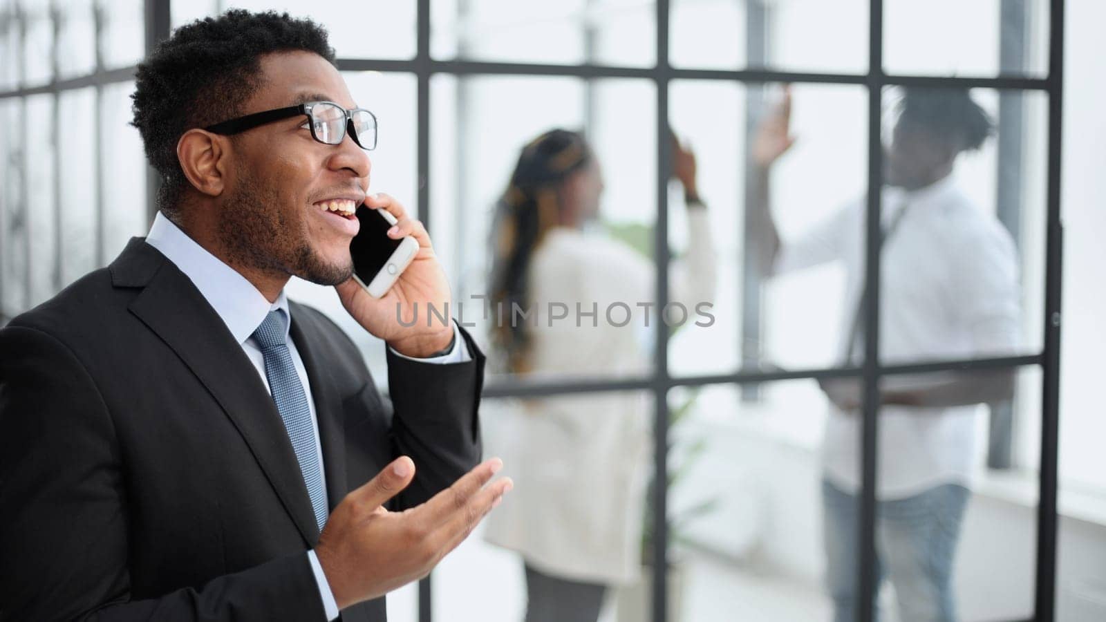 Good connection. Young african guy talking by cell phone and smiling