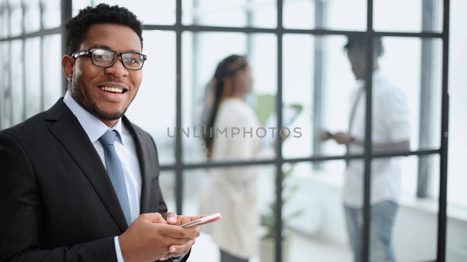 African American businessman in elegant black suit looking at the camera