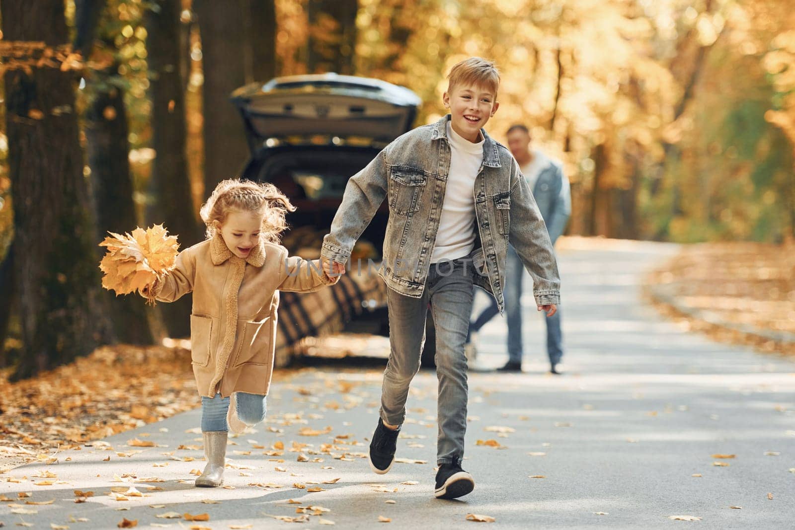 Weekend activities. Happy family is in the park at autumn time together.
