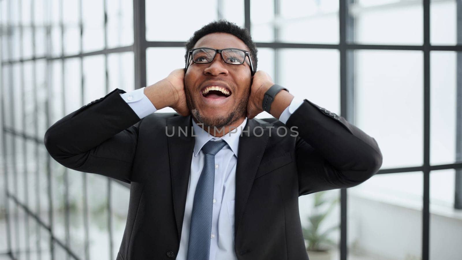 Photo of a young excited guy rejoicing in his luck in a black suit
