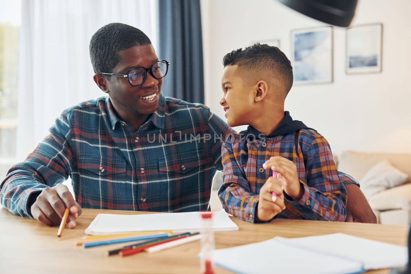 Drawing lessons. African american father with his young son at home.