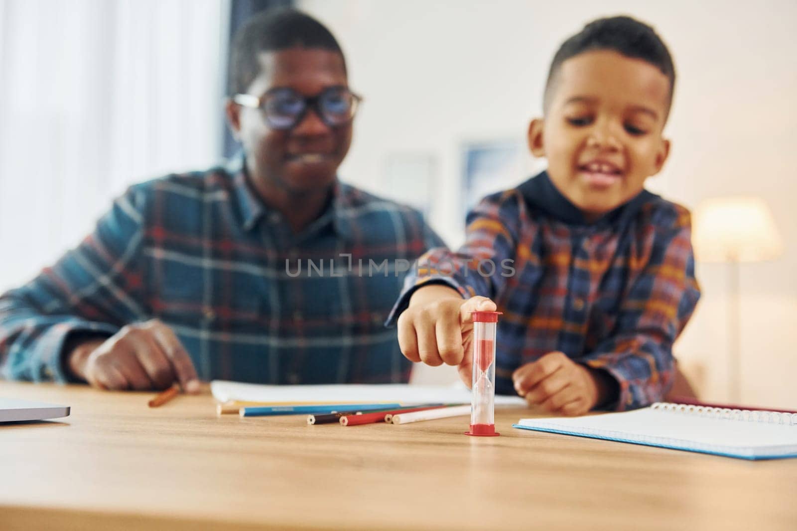 Drawing lessons. African american father with his young son at home.