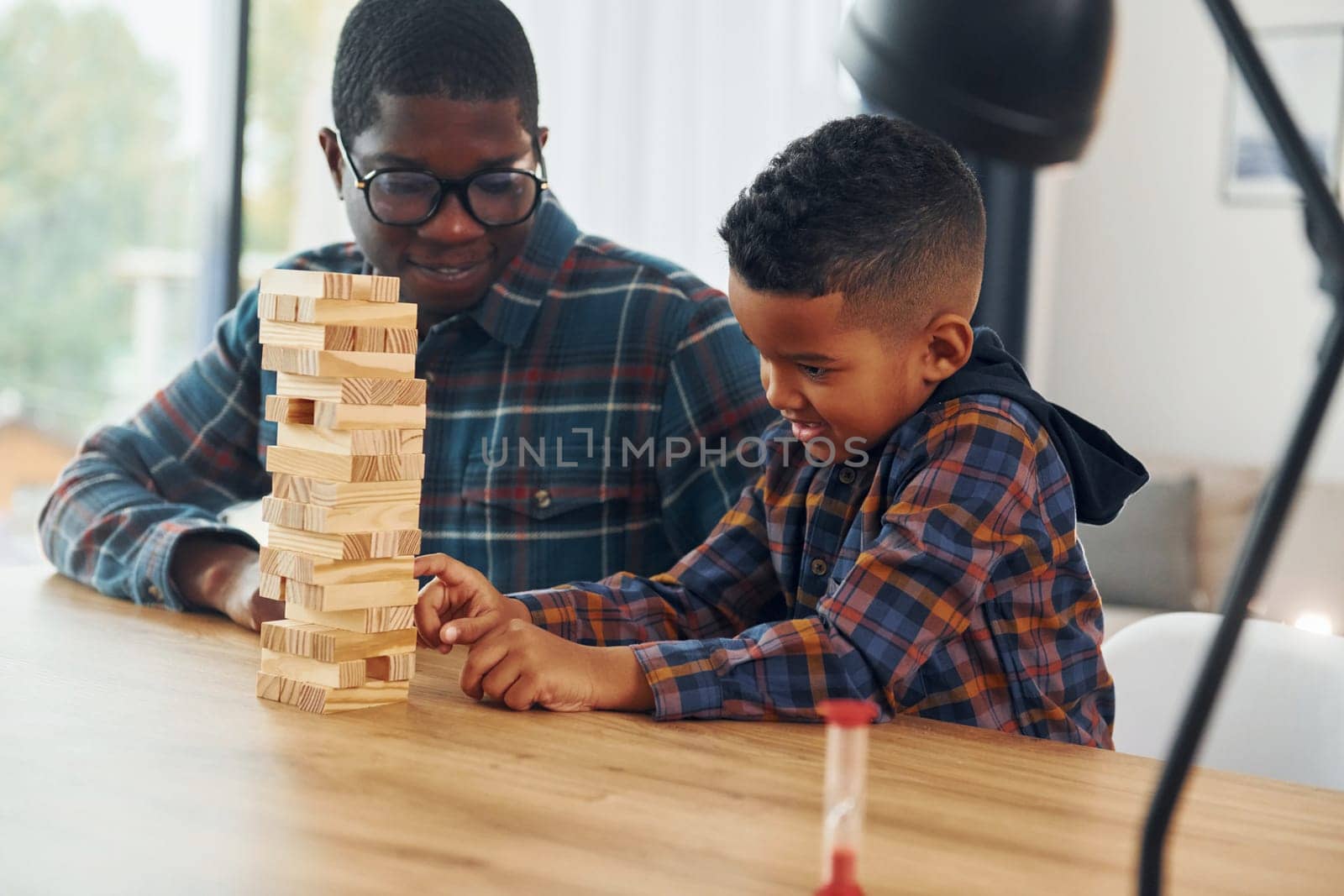 Playing bricks game. African american father with his young son at home.