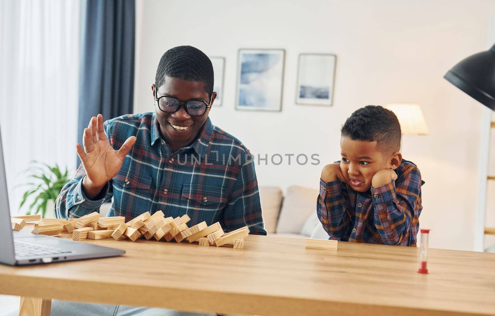 Playing together. African american father with his young son at home.