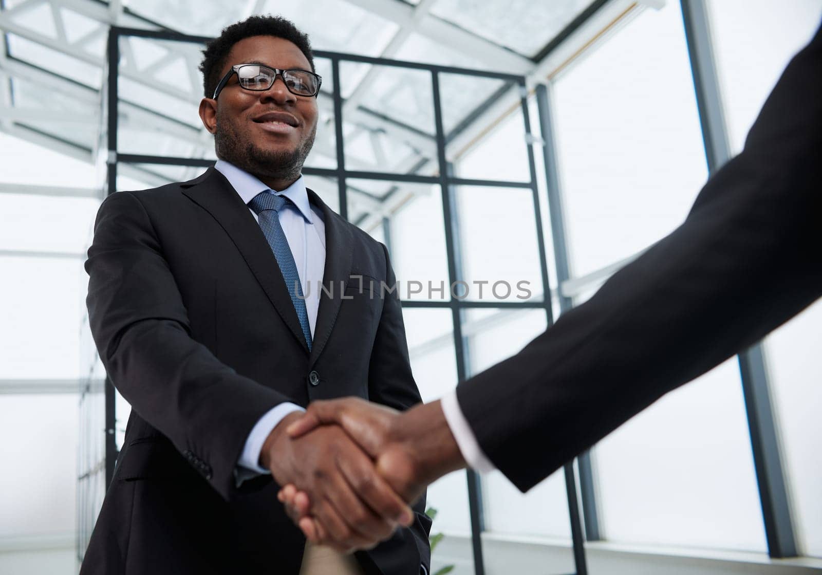 Shot of a young businessman shaking hands with a colleague in the office