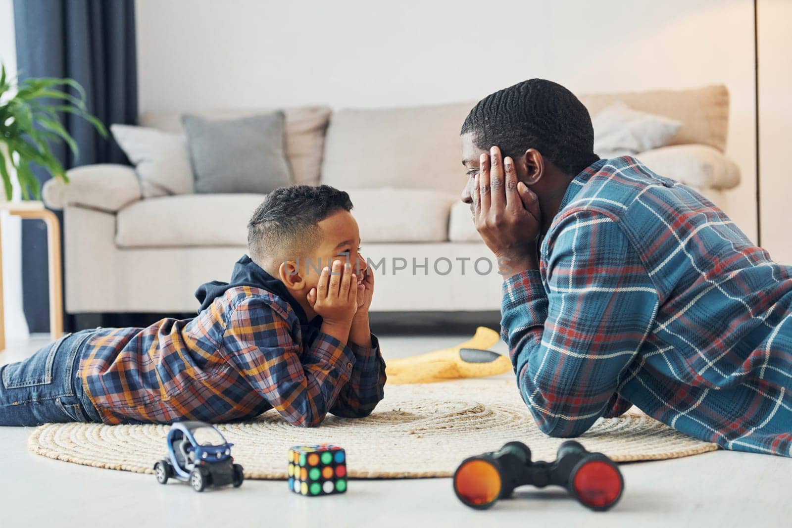 Playing together. African american father with his young son at home.
