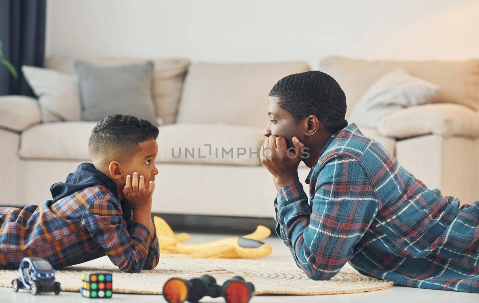 Playing together. African american father with his young son at home by Standret