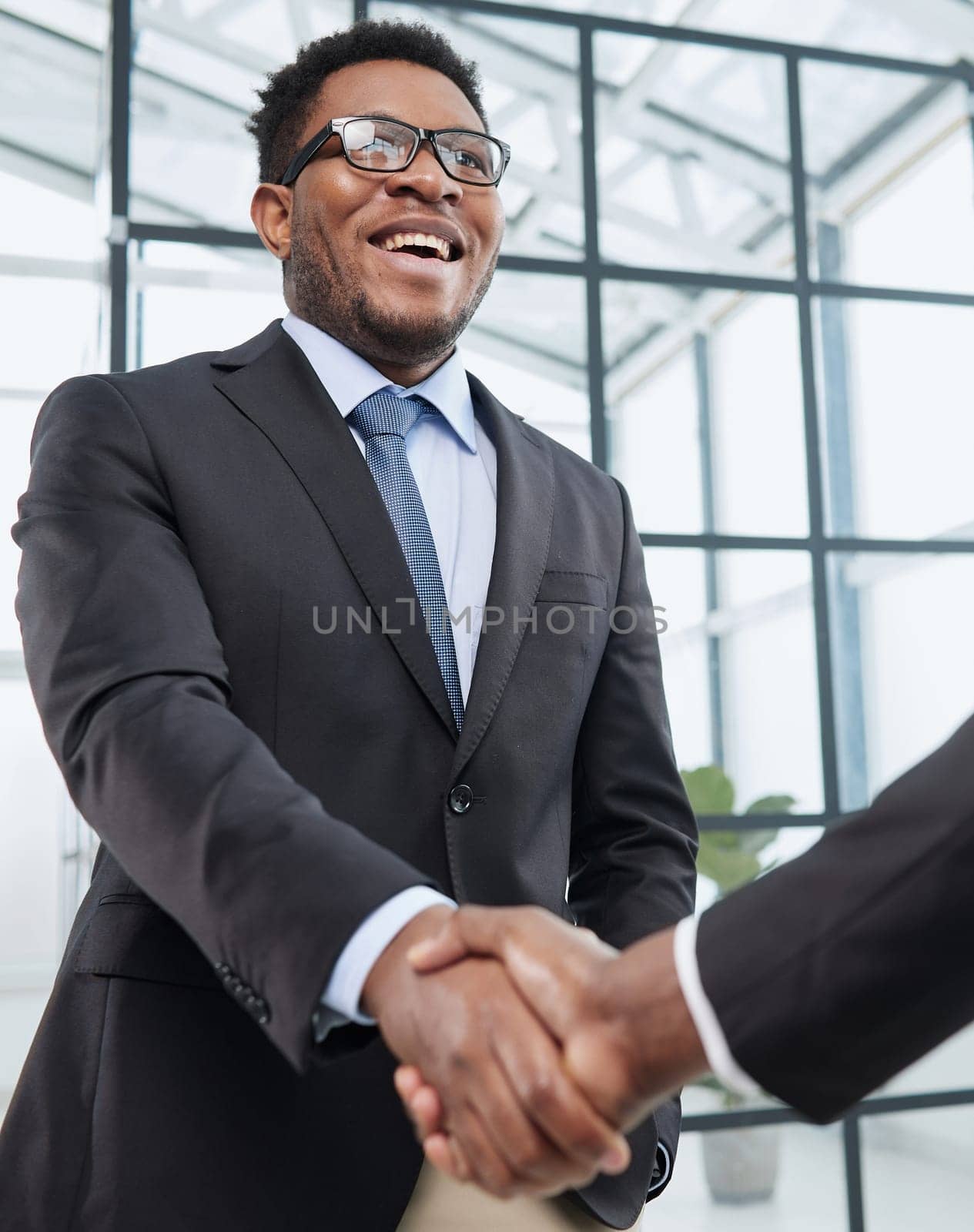 Shot of a young businessman shaking hands with a colleague in the office