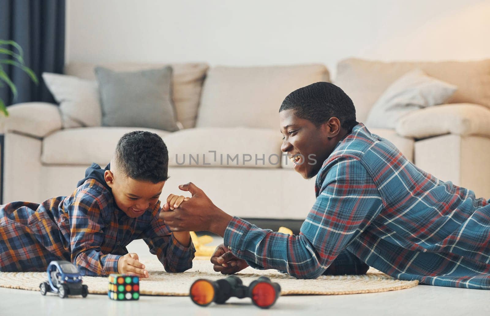 Side view. African american father with his young son at home.