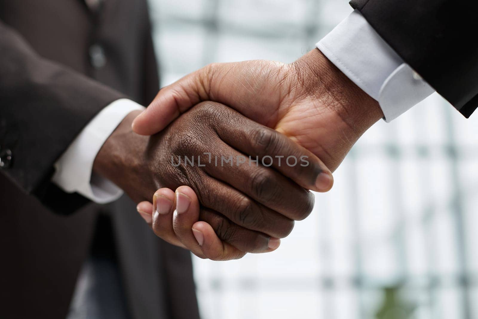 young businessmen shaking hands in the office close-up