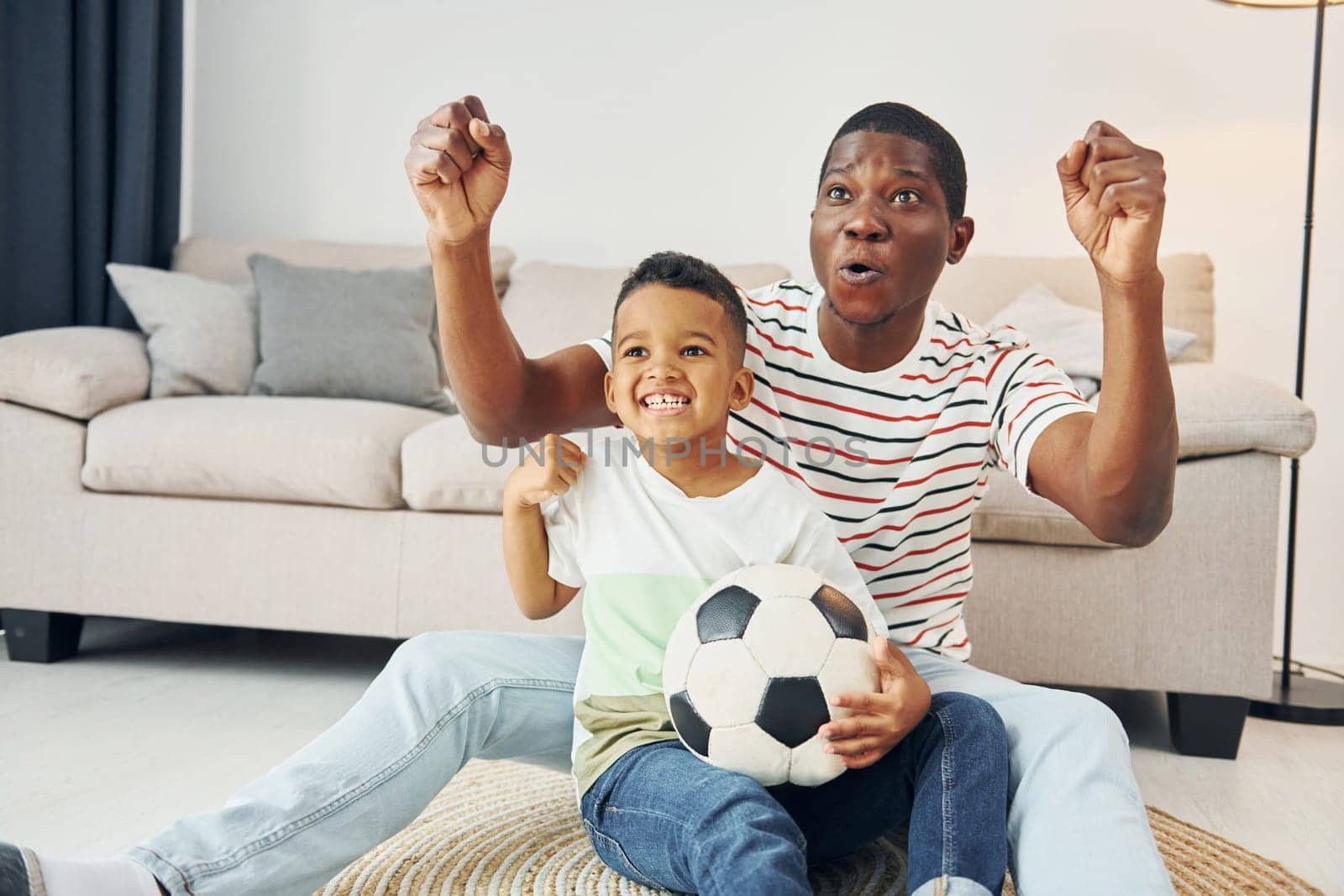 Entertainment for people. African american father with his young son at home.