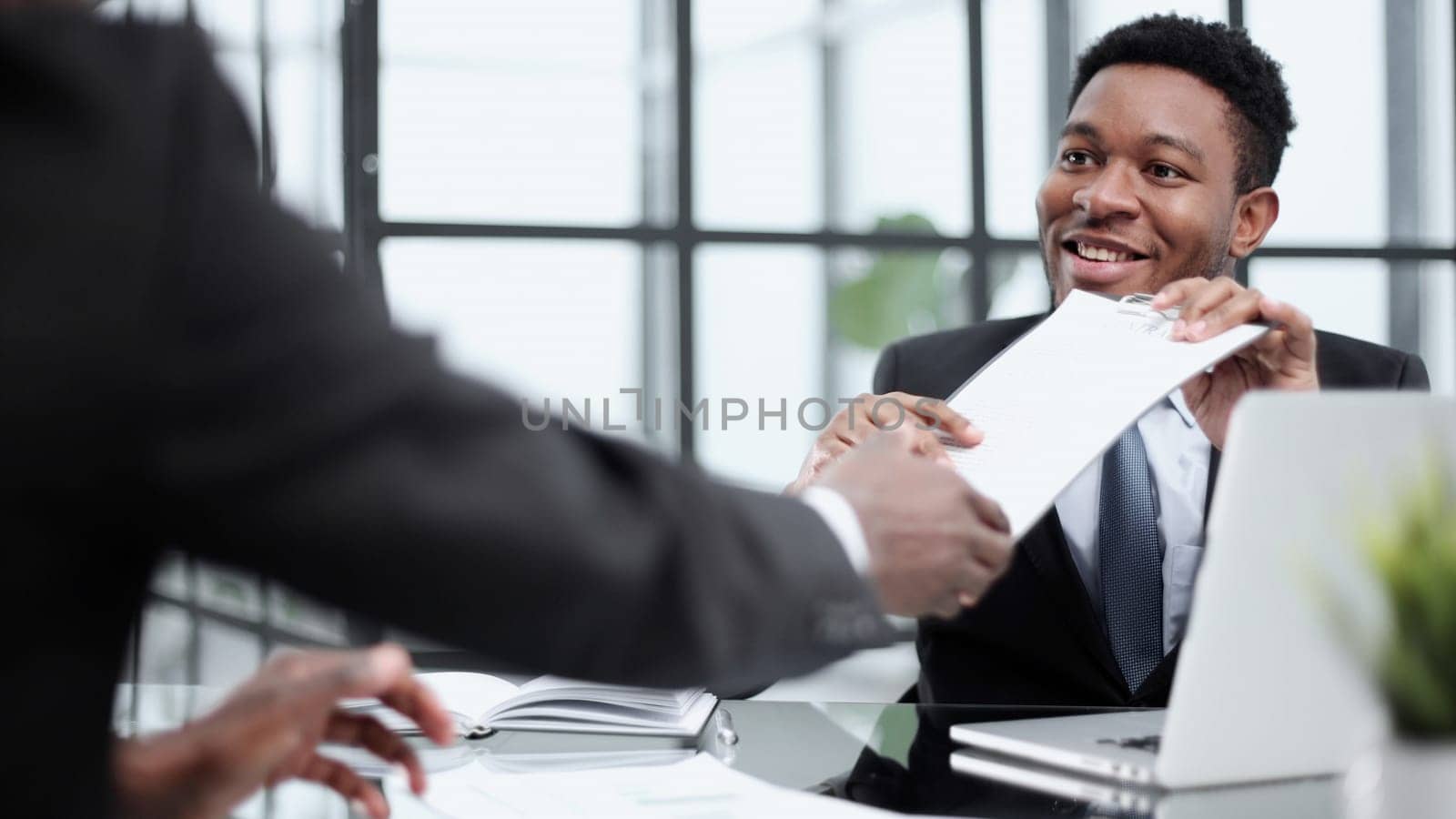 Shot of two young businesmen shaking hands in a modern office