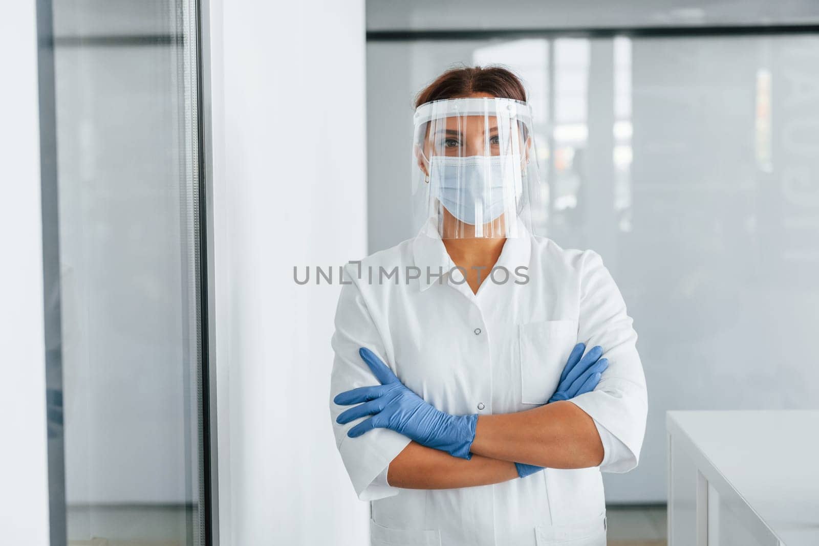 Standing indoors. Professional medic in white coat is in the clinic.