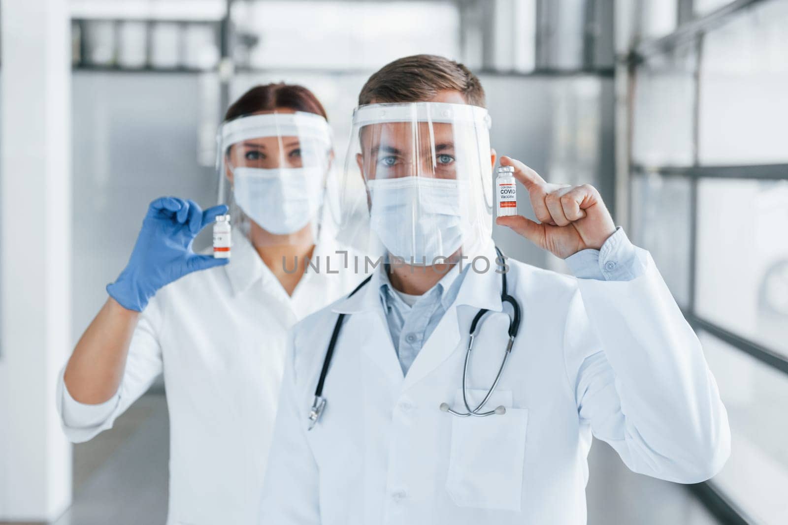 Two doctors in white coats is in the clinic working together.