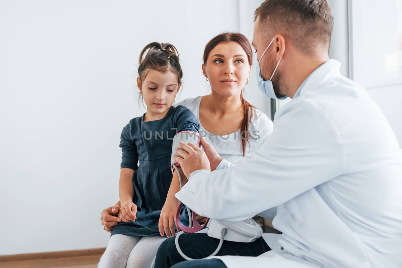 Helping kid. Two doctors in white coats is in the clinic working together.