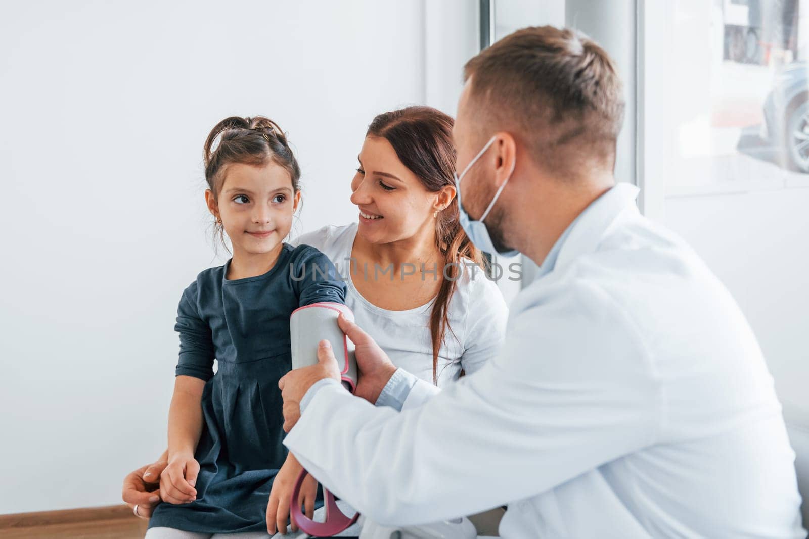 Helping kid. Two doctors in white coats is in the clinic working together.