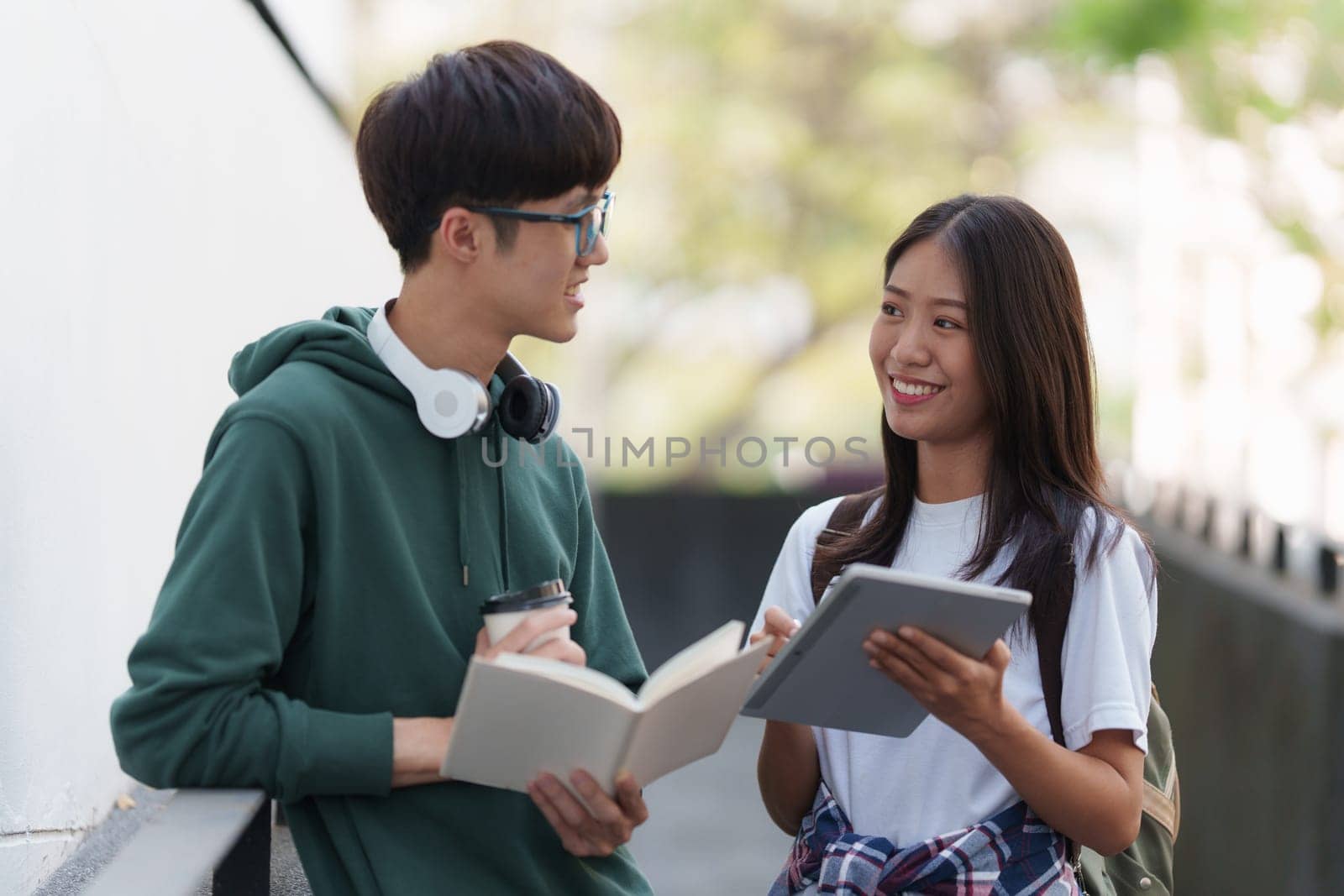 Young Asian woman college student with friends at outdoors. College student working on the college campus, education, school, study.