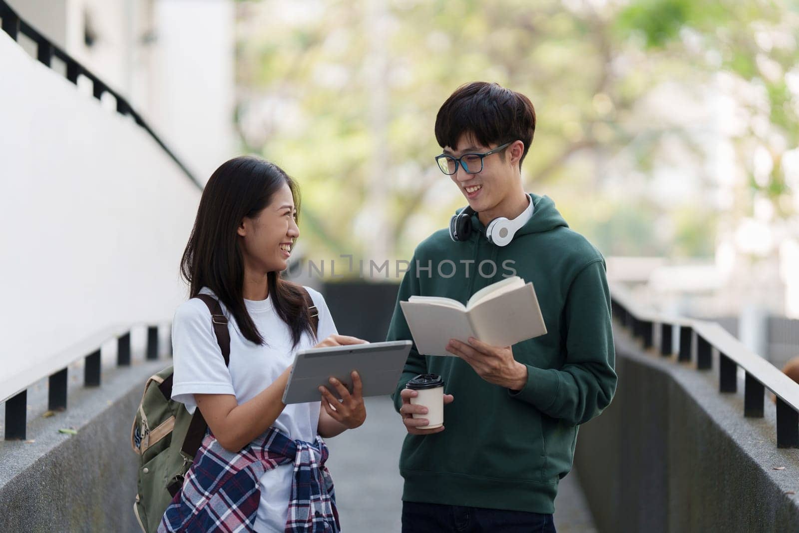 Young Asian woman college student with friends at outdoors. College student working on the college campus, education, school, study.