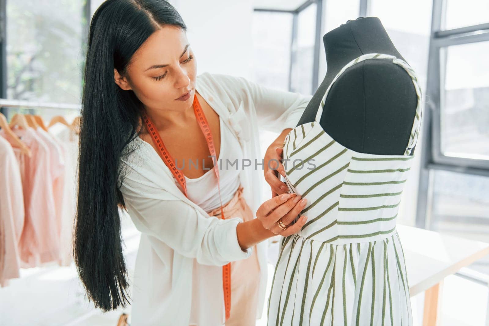 Measuring clothes. Seamstress is in her office.