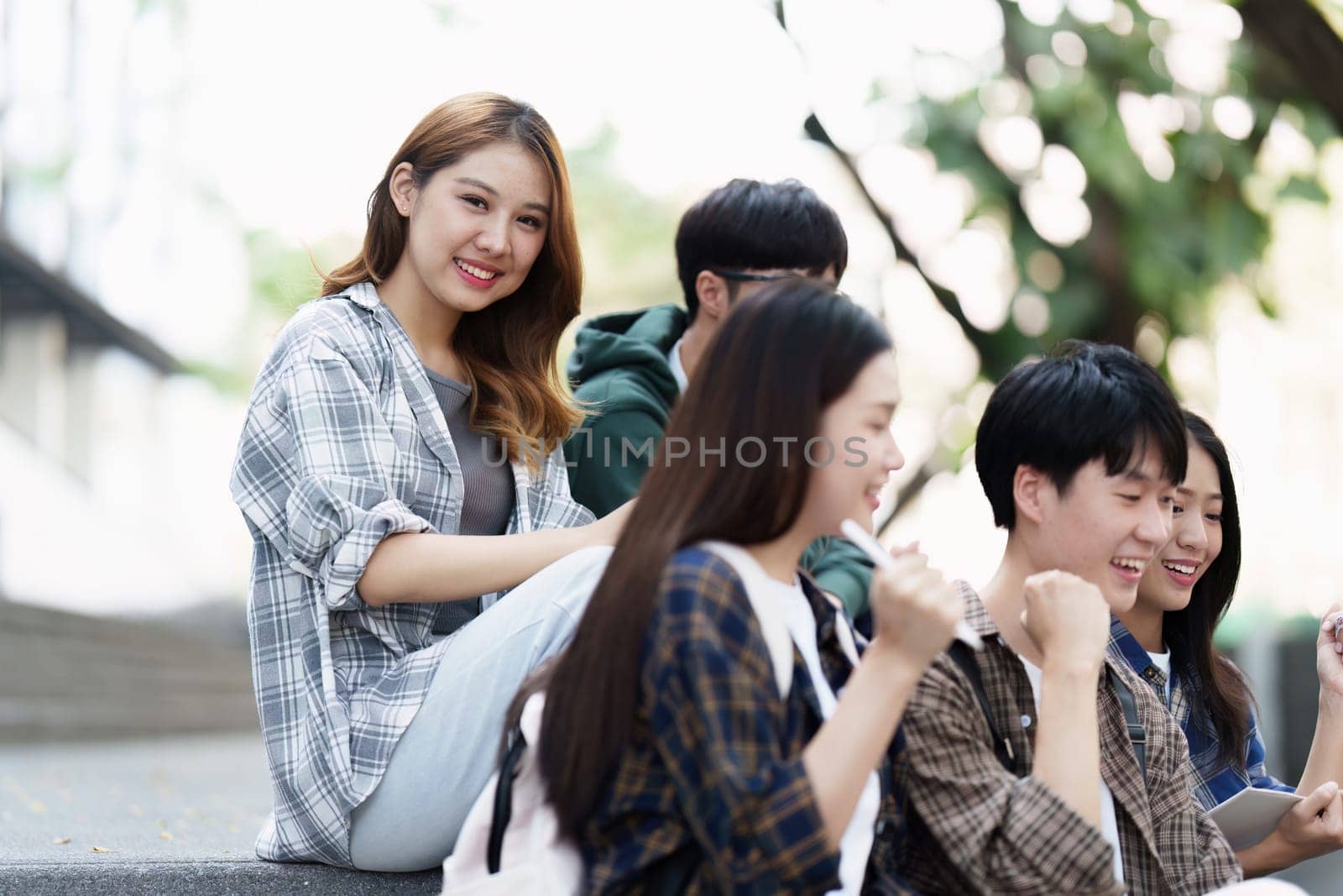 Young Asian woman college student with friends at outdoors. College student working on the college campus, education, school, study by itchaznong