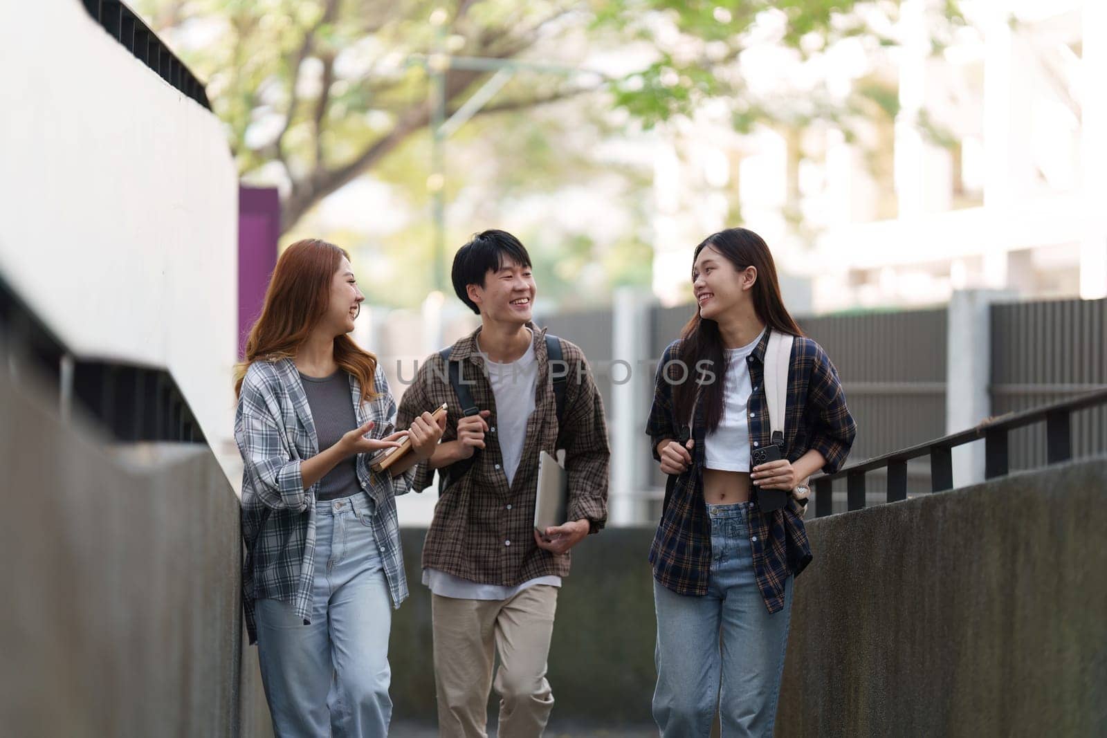 Young Asian woman college student with friends at outdoors. College student working on the college campus, education, school, study.