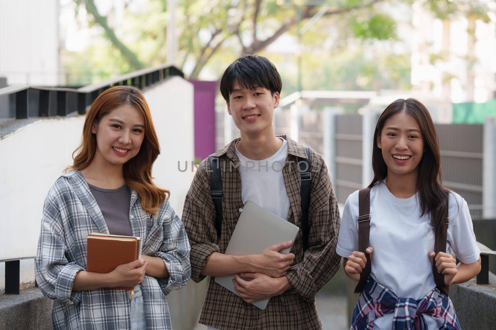 Young Asian woman college student with friends at outdoors. College student working on the college campus, education, school, study by itchaznong
