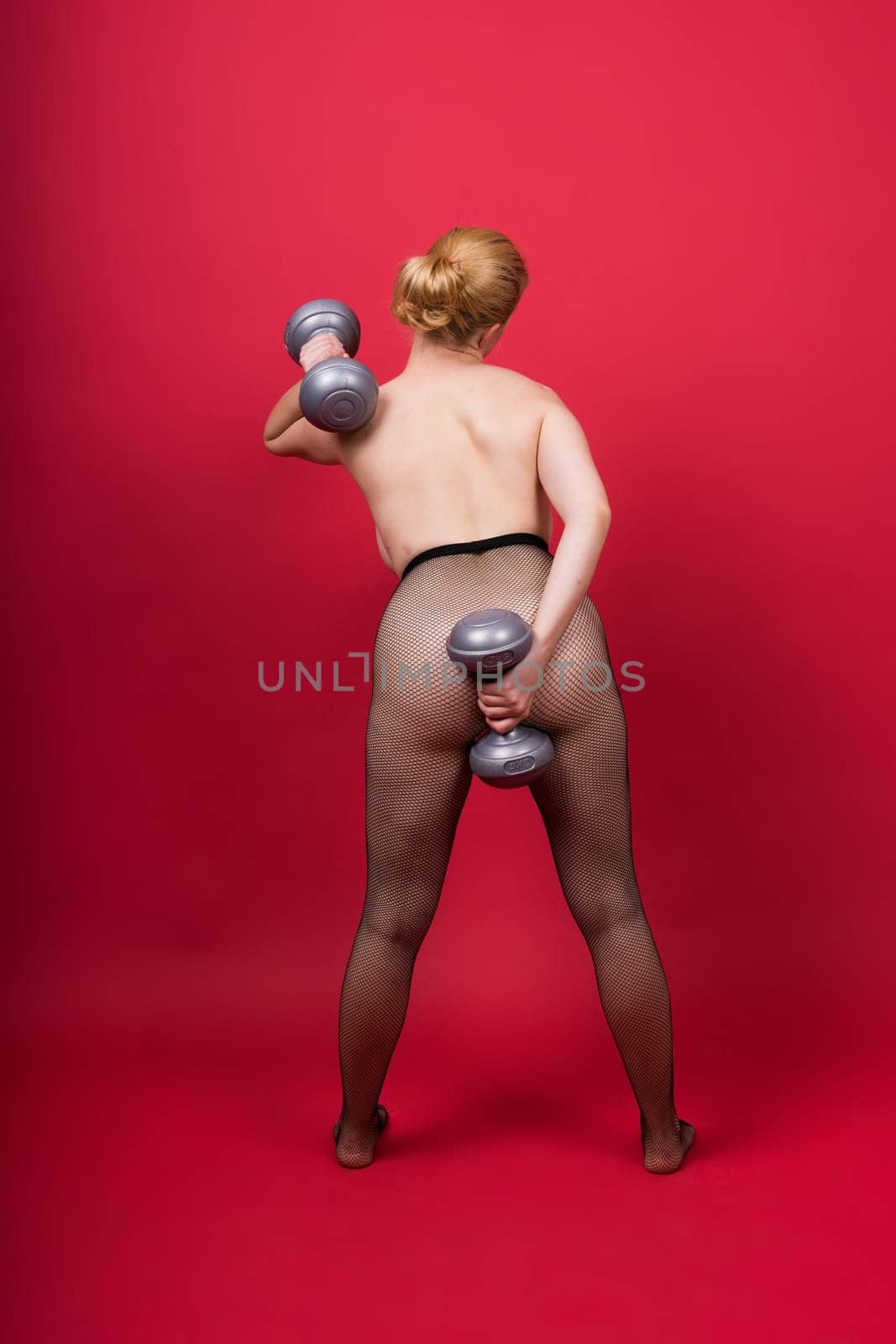 Seductive beautiful fitness female, athletic woman working out with dumbbells. Isolated in studio by Zelenin